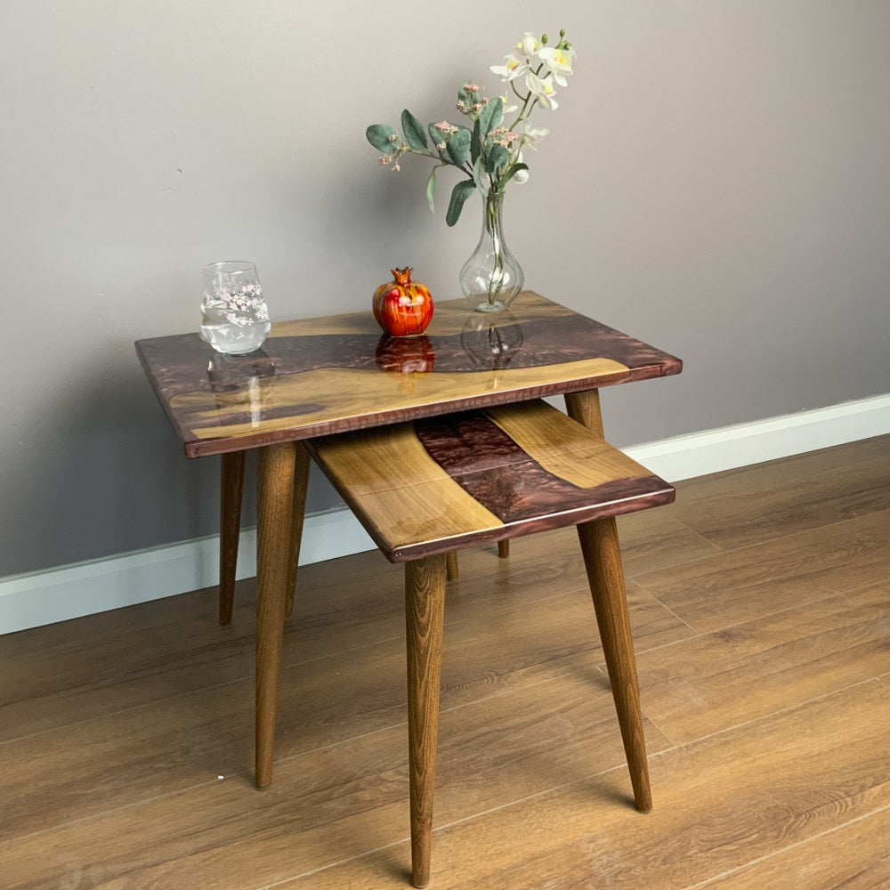 Two walnut nesting tables with vases, showcasing a burgundy river epoxy design. Perfect for stylish home decor.