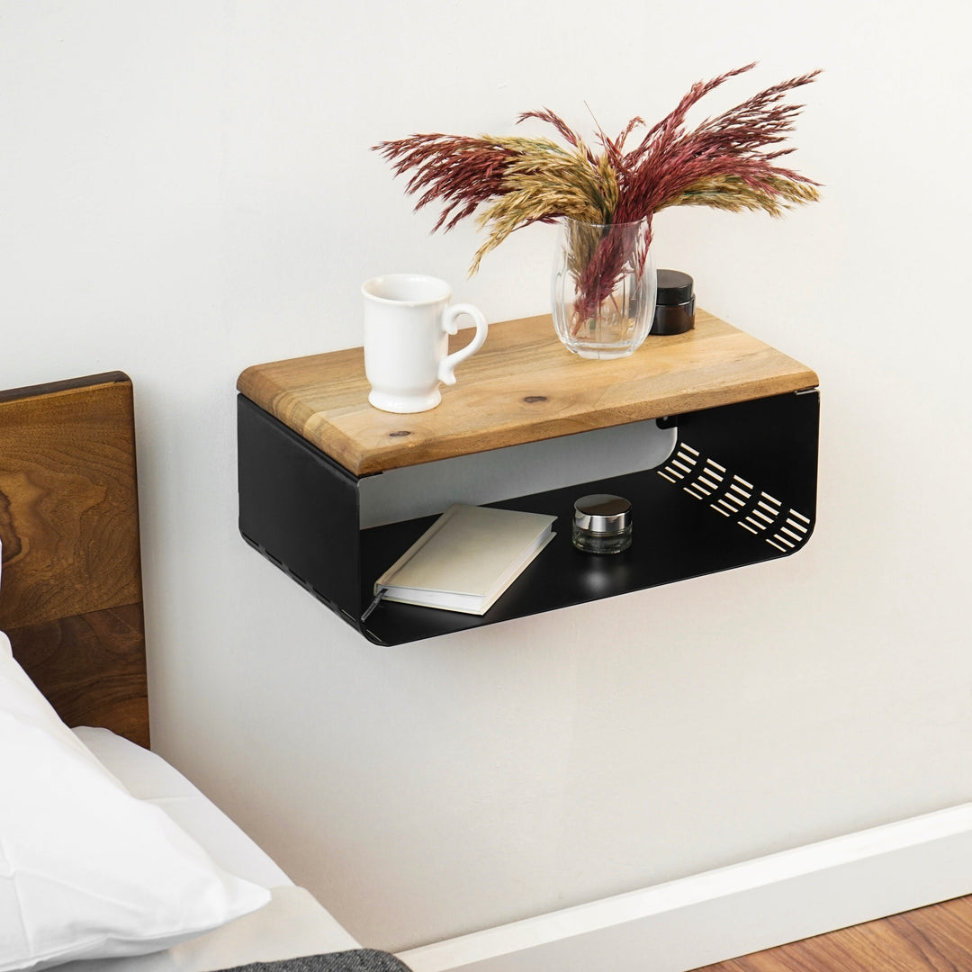 A floating nightstand with a walnut top, featuring a vase of flowers on the shelf above.