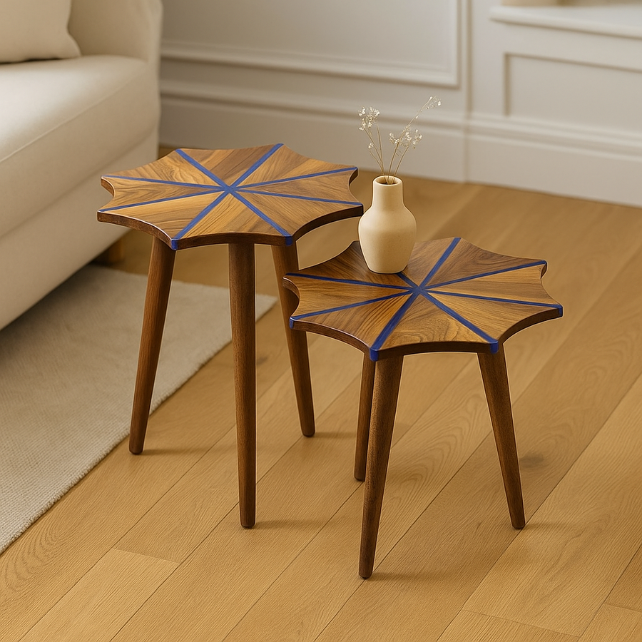Set of two walnut nesting side tables with blue epoxy stripes in a snowflake star pattern, on a light wood floor