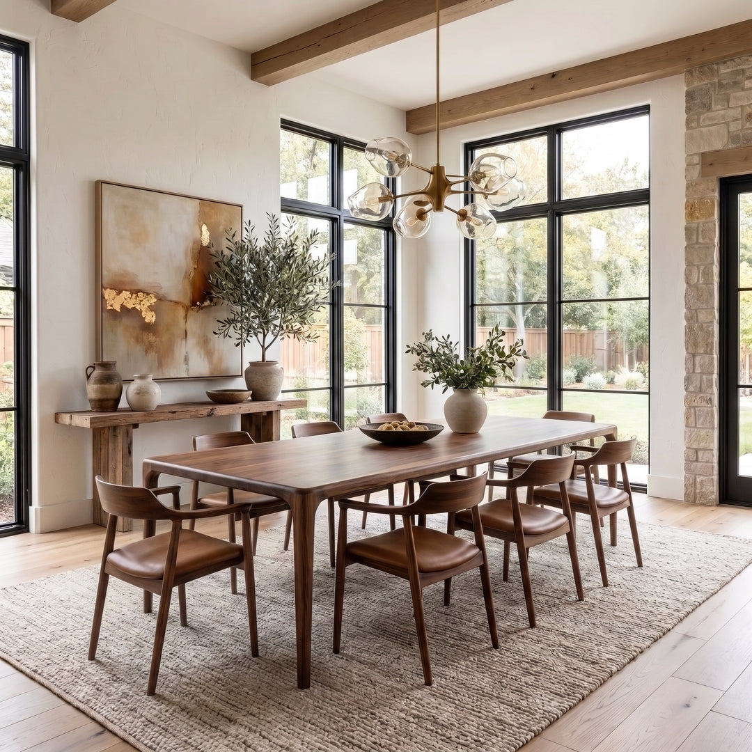 Oslo walnut dining table in a modern dining room with exposed beams, black framed windows and a brass chandelier