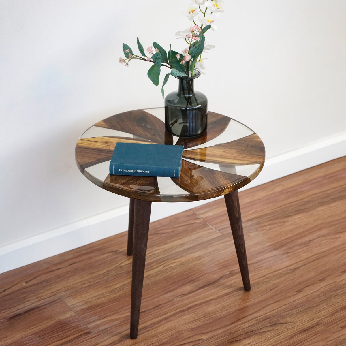 Walnut side table with clear epoxy windmill top, angled view with a book on the table
