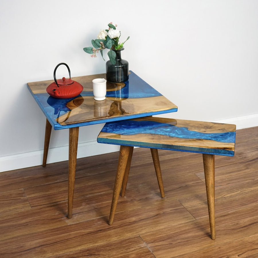 Walnut nesting table set of 2 with blue epoxy river, large table angled over the small one, red teapot on top
