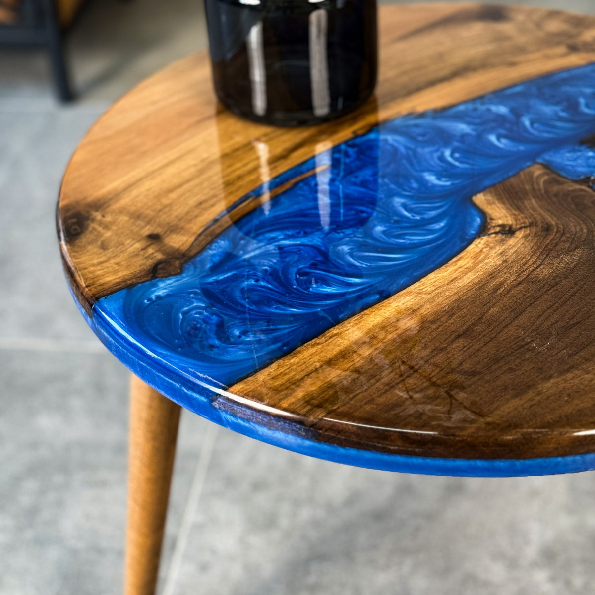 Close-up of the blue epoxy river and walnut grain at the edge of the round side table top