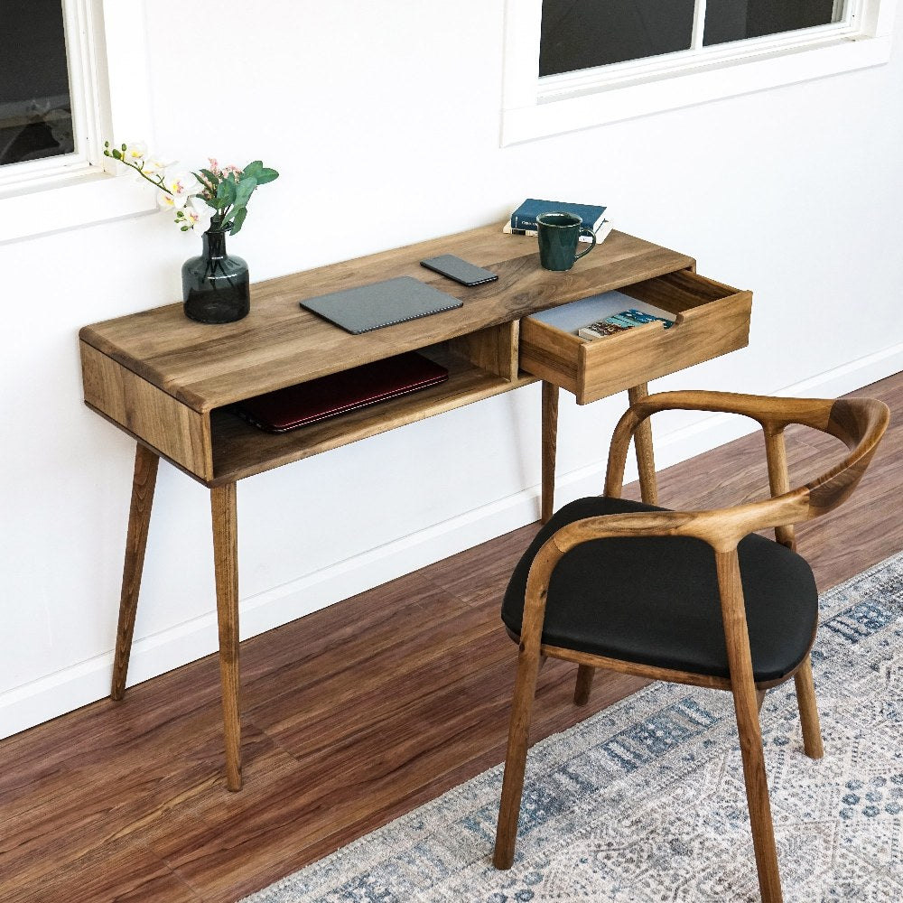 Walnut boho desk with the drawer open, angled view with a wooden armchair beside it