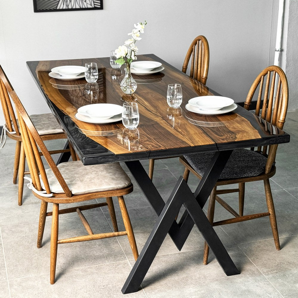 Walnut dining table with black epoxy sides and metal legs, corner view in a gray room with spindle back chairs