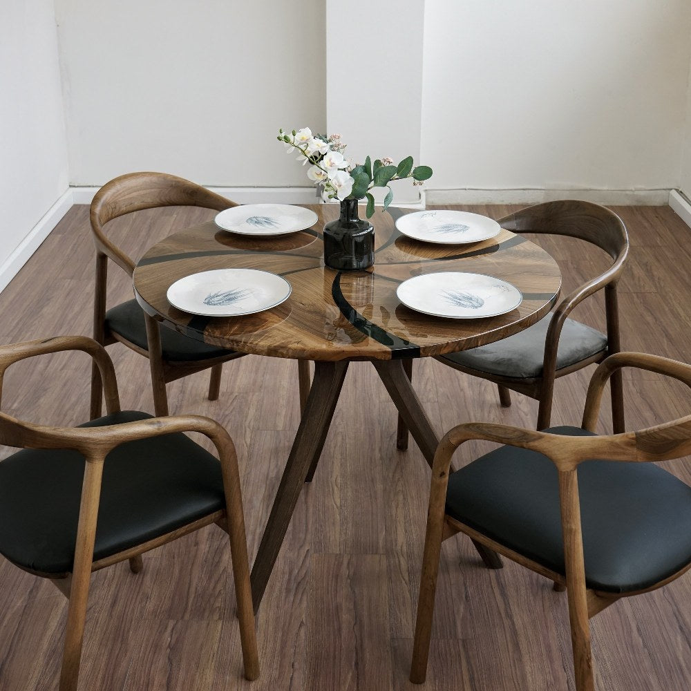 Overhead angle on the round walnut dining table with black epoxy swirl, set for four with armchairs