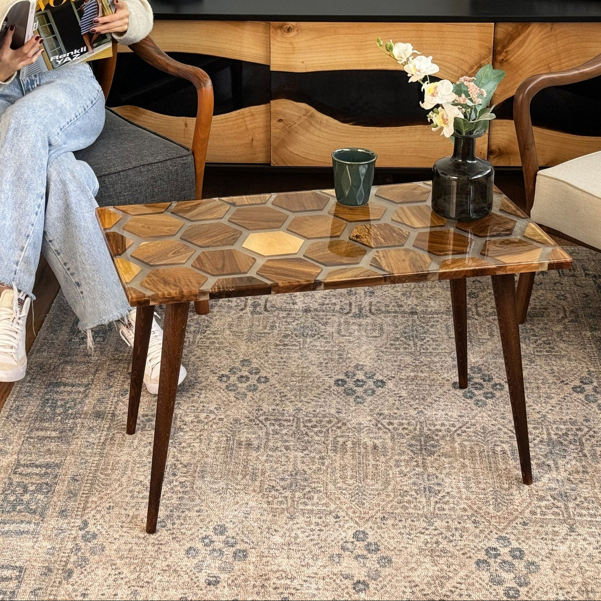 Honeycomb walnut epoxy coffee table from the left with tapered legs and a glass vase on top