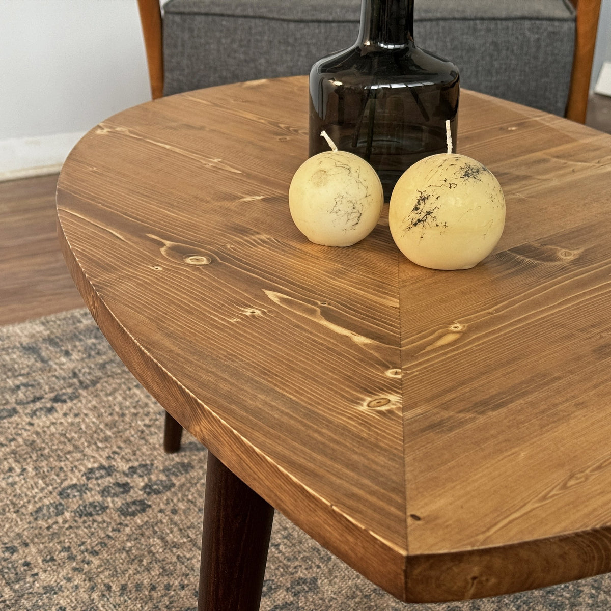 Close-up of the leaf shaped tabletop corner and edge thickness with two round candles