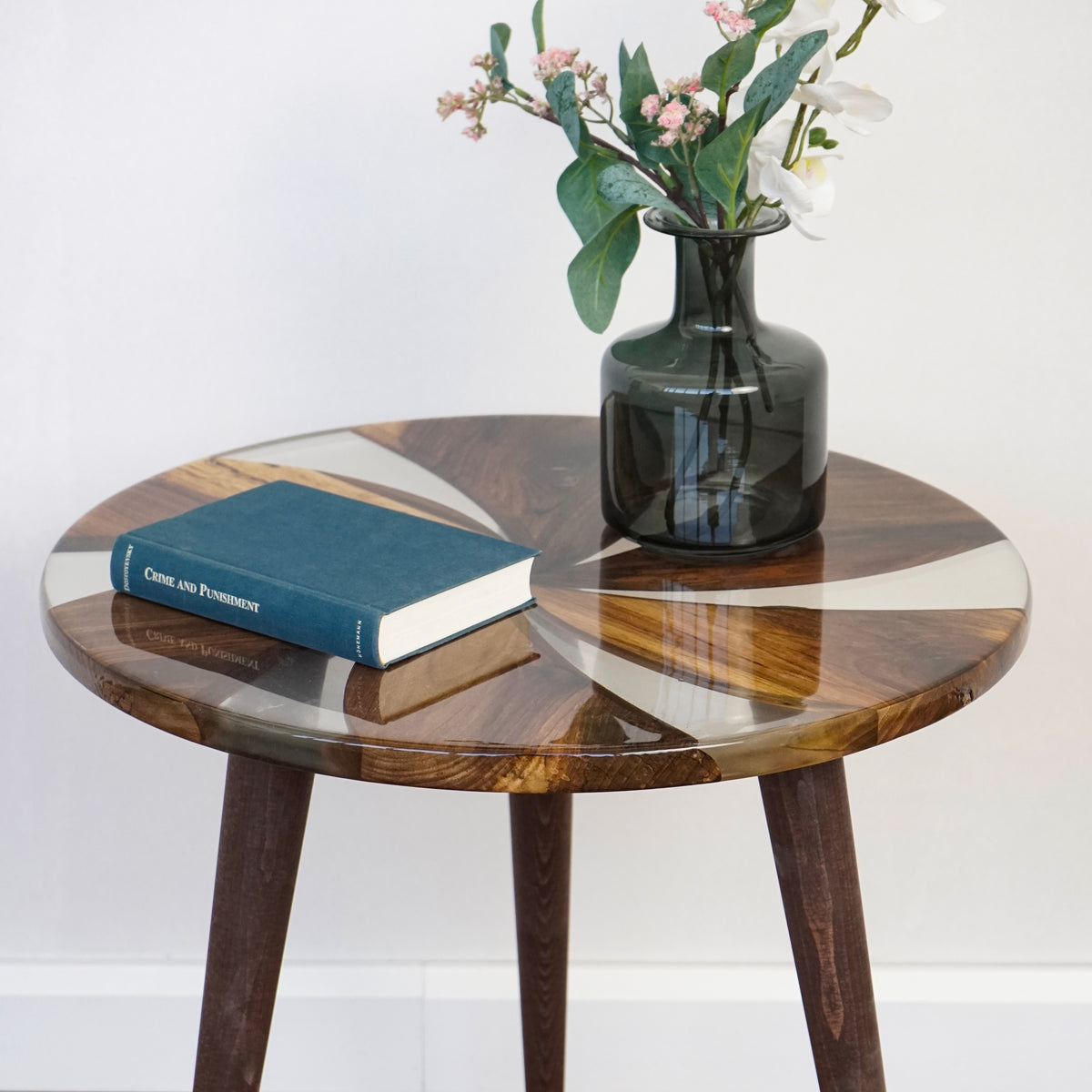 Close-up of the walnut and clear epoxy windmill top with a book and a vase of flowers