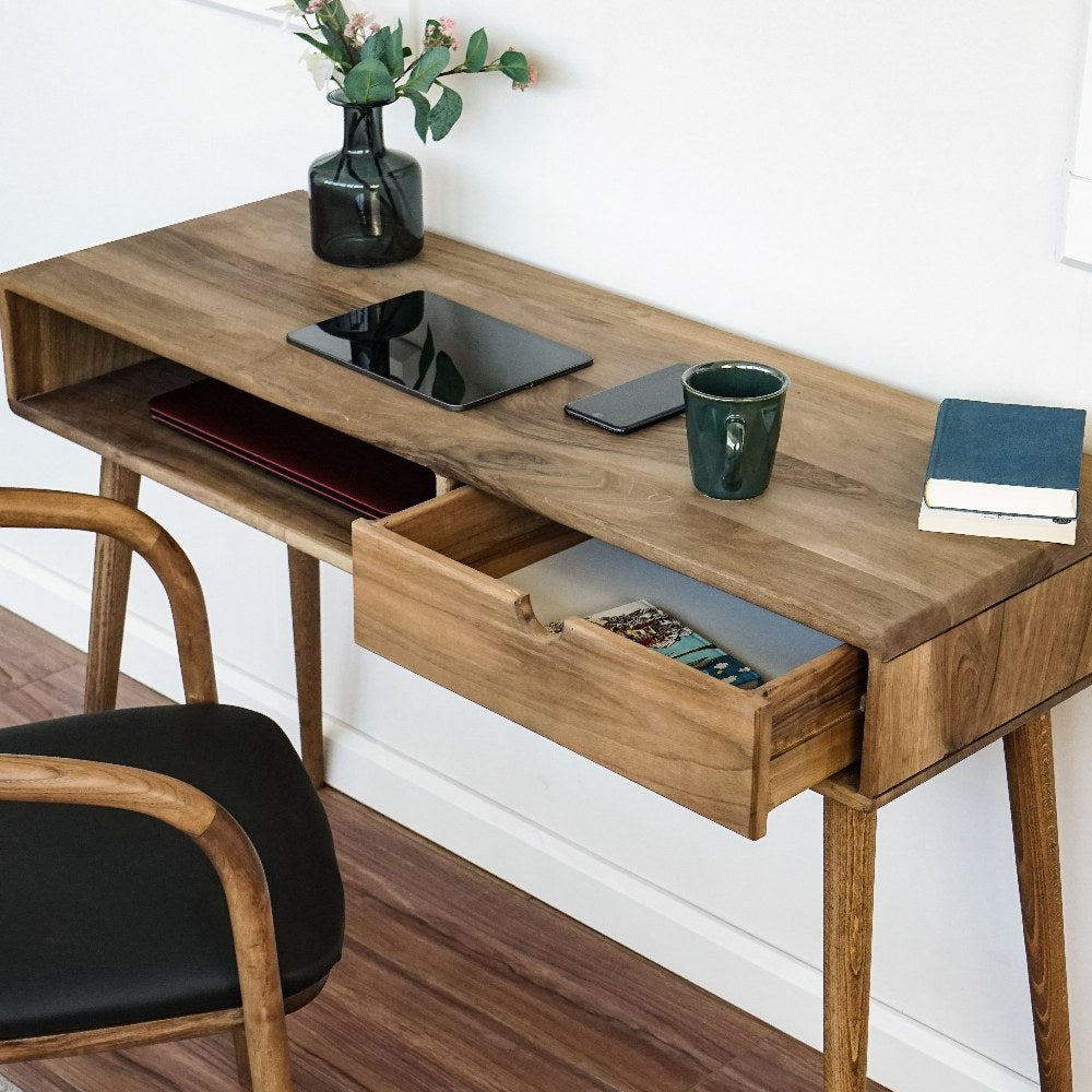 High angle of the walnut desk top with the drawer pulled open and a tablet on top
