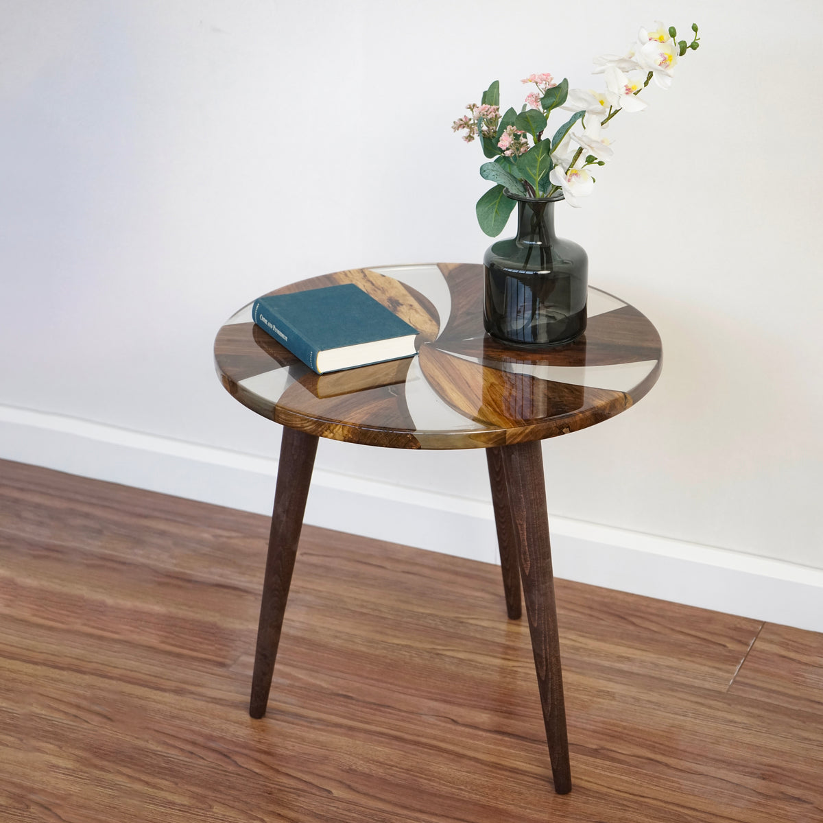Side view of the round walnut epoxy side table showing the windmill top and three tapered legs