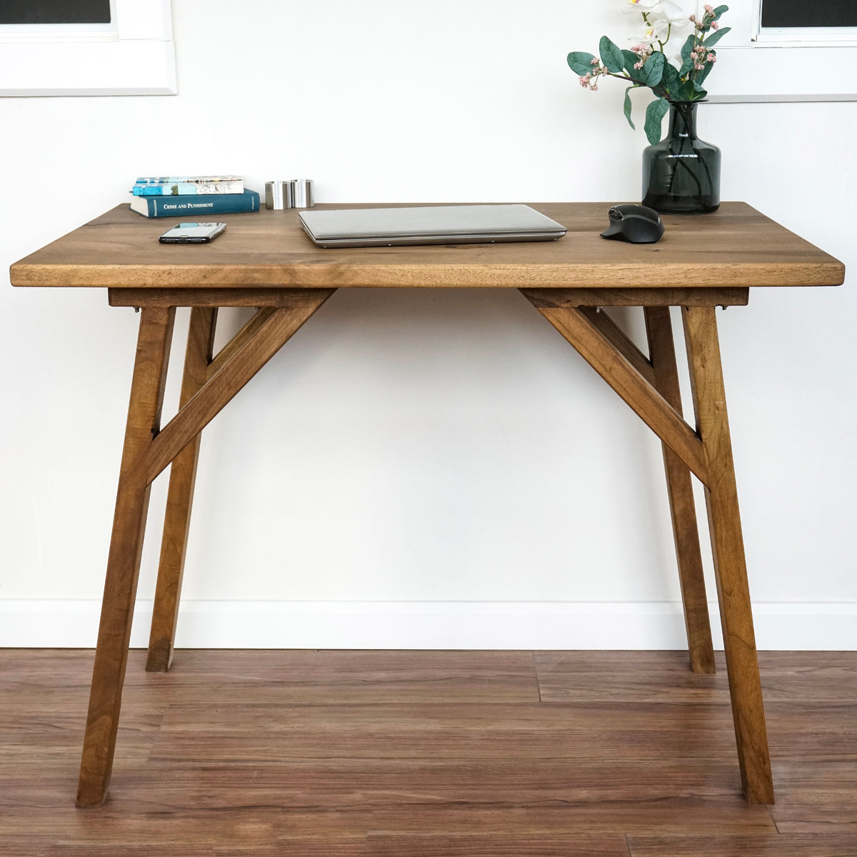 Front view of the rectangle-edge small walnut desk with angled legs and brace supports