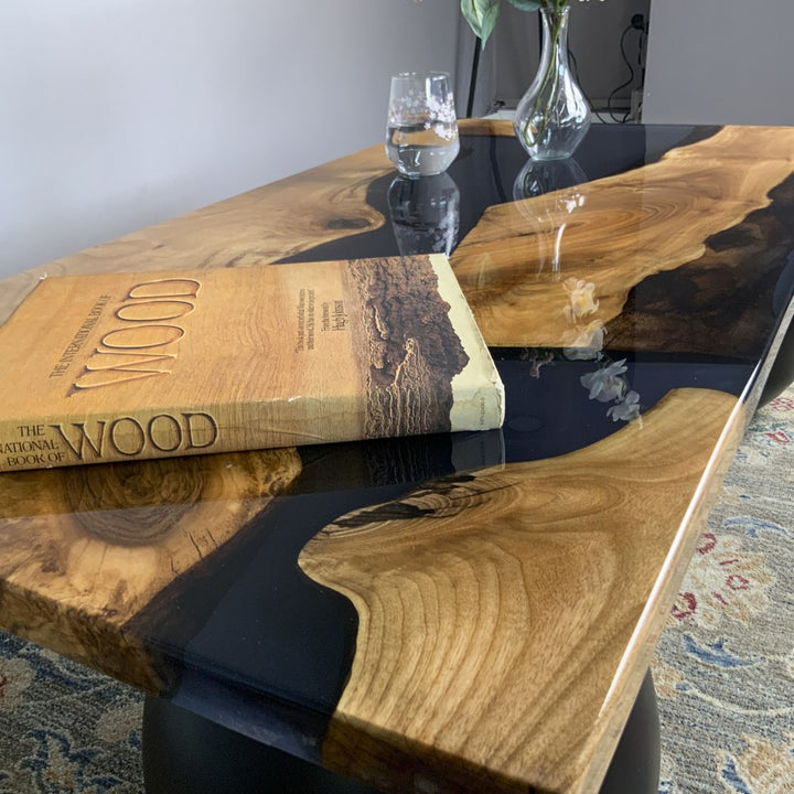 Close-up of walnut grain and black epoxy resin on the corner of the river coffee table