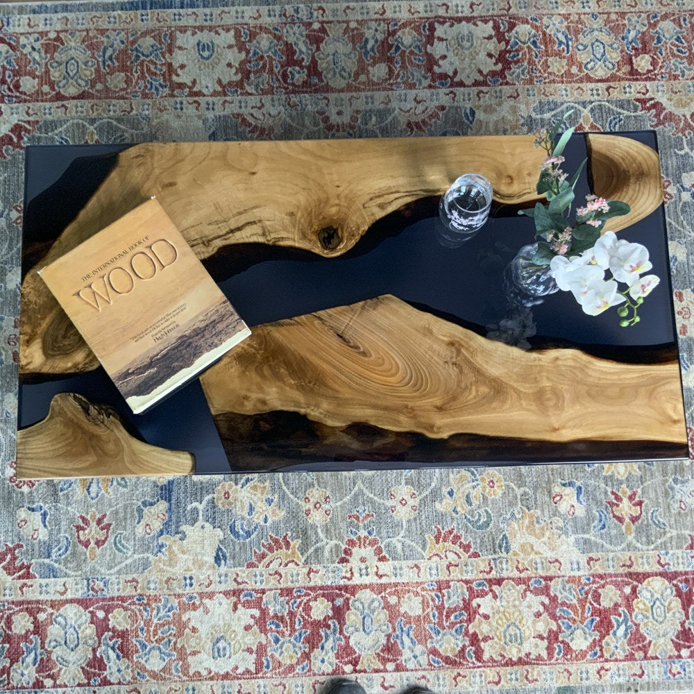 Overhead view of the black epoxy river coffee table showing the walnut slabs and resin channel