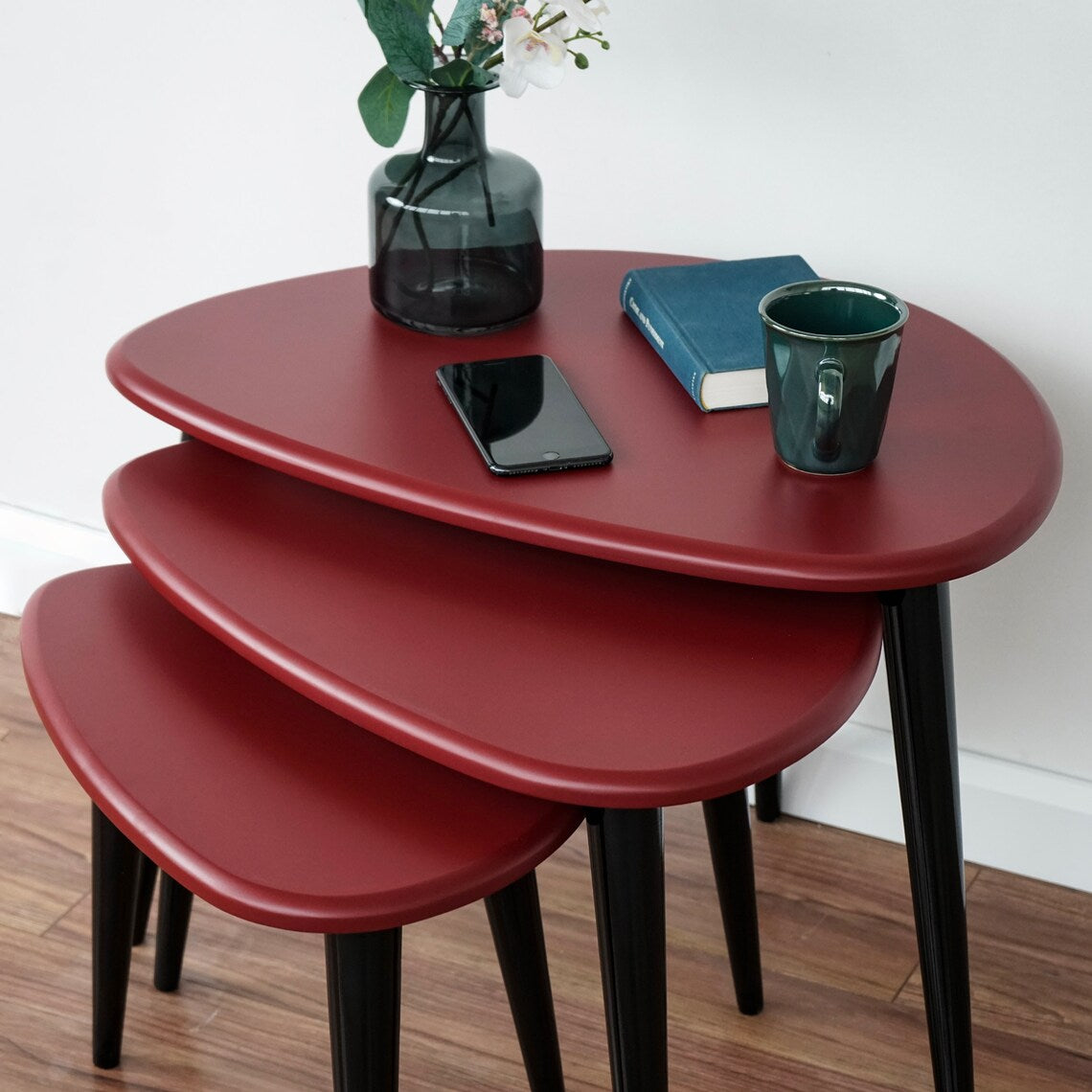 Top angle on the burgundy pebble nesting tables showing the three nested tops