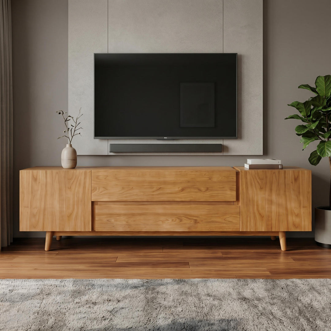 Wooden TV stand with a television mounted on a wall in a room with a plant and decorative items.