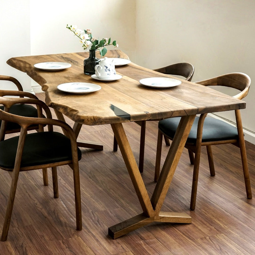 Close view of the live edge end of the walnut farmhouse table with a teapot and chairs