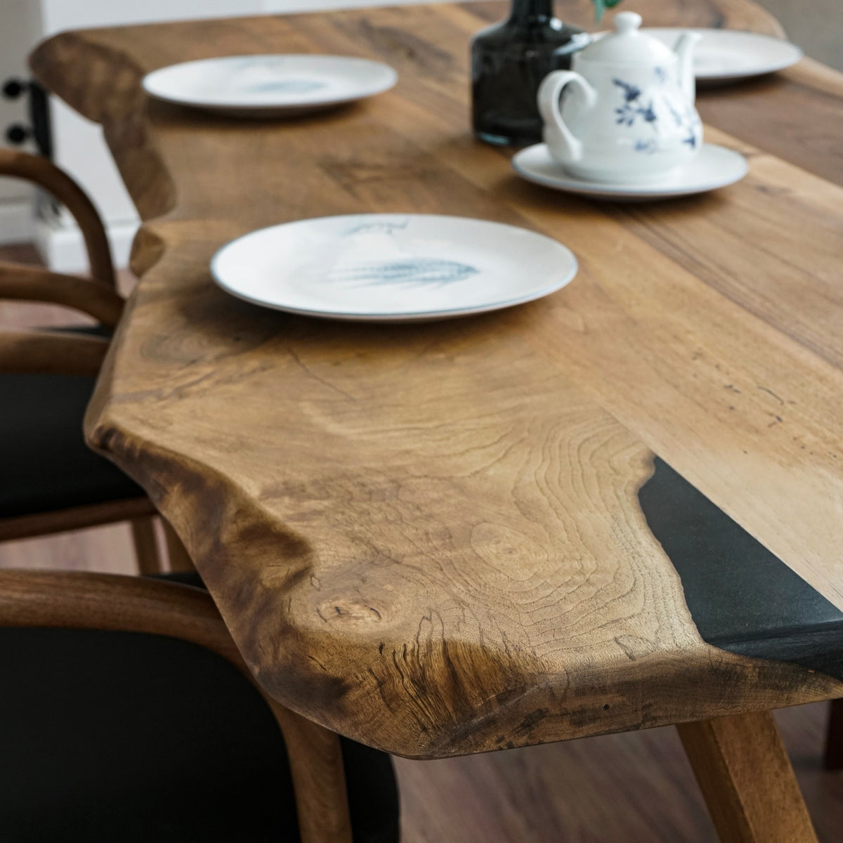 Close-up of the live edge and black fill on the walnut farmhouse table with a plate