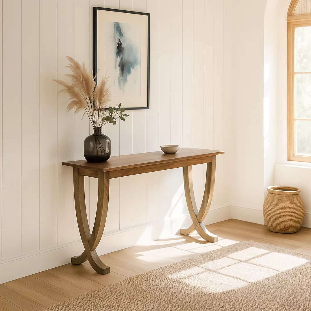 Walnut console table with curved legs in a white paneled room with sunlight on the floor
