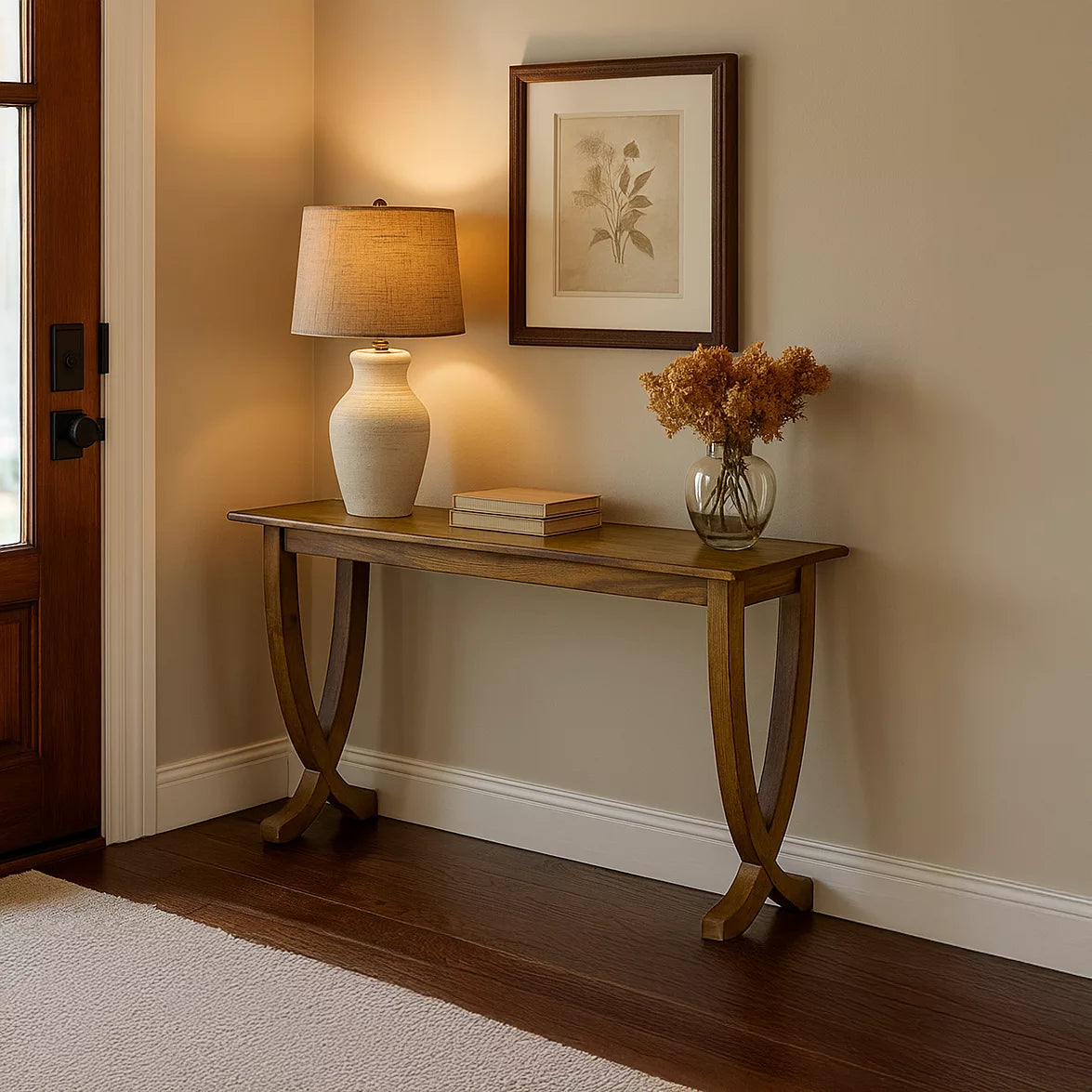 Front view of the walnut console table with curved legs in an entryway beside a wooden front door