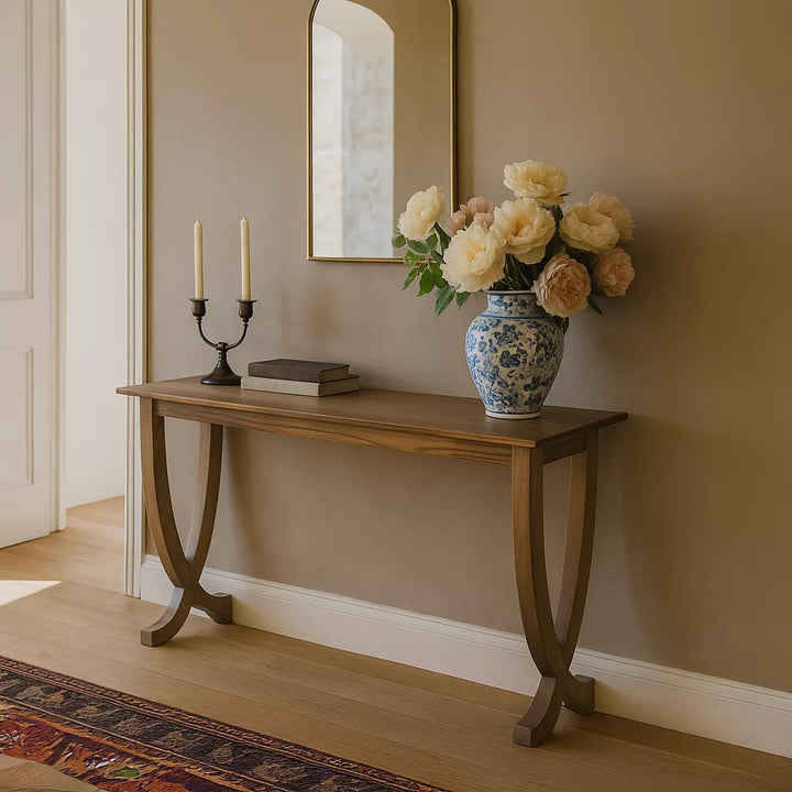 A contemporary walnut console table displaying fresh flowers and a mirror, enhancing the room's modern aesthetic.