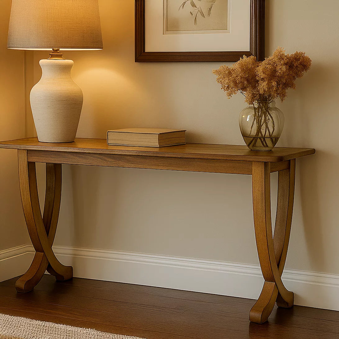 Close view of the walnut console table's slim top and curved legs on a dark wood floor