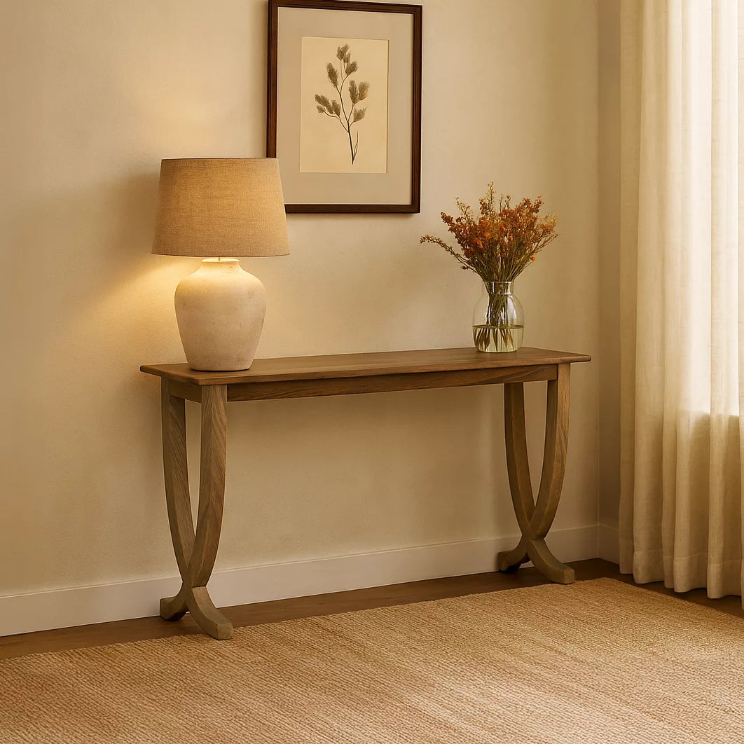 Front view of the walnut console table and its curved legs on a woven rug near a curtain