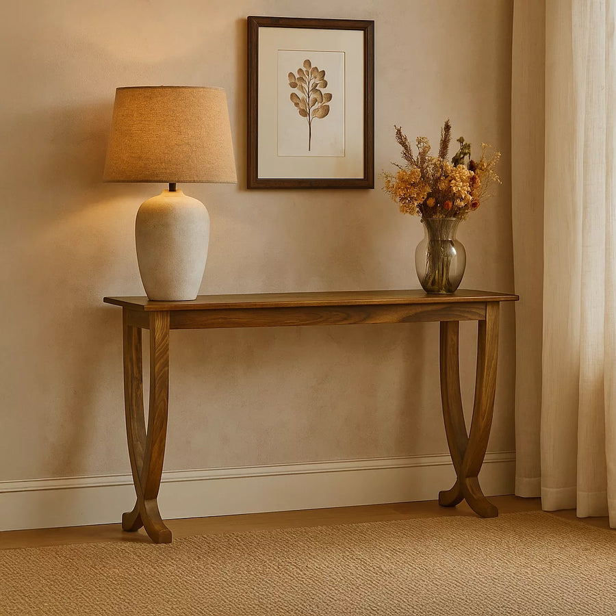 Contemporary walnut console table with curved legs against a plaster wall beside a curtain