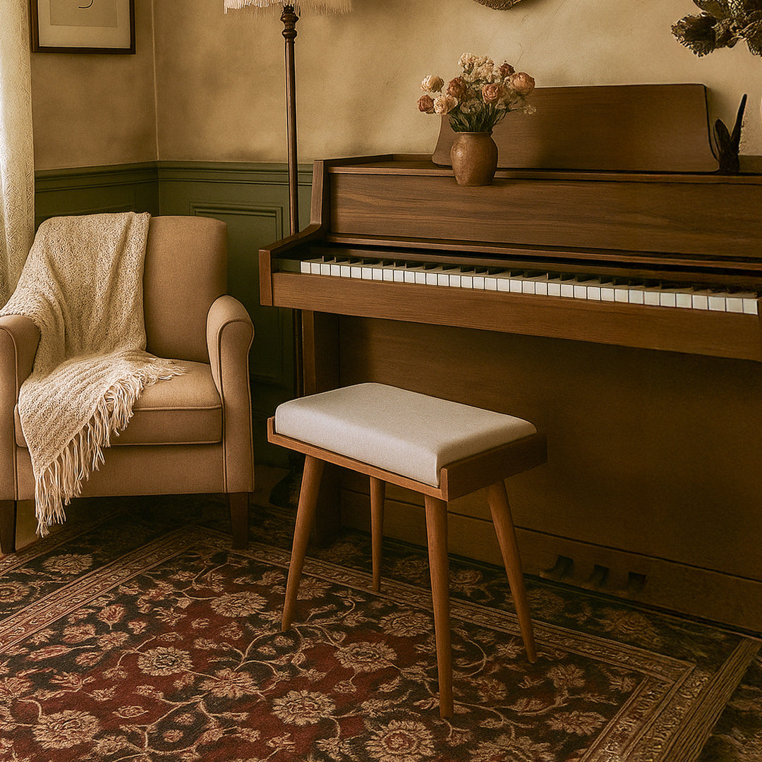 Wooden piano with a chair and stool in a room with a patterned rug and lamp.