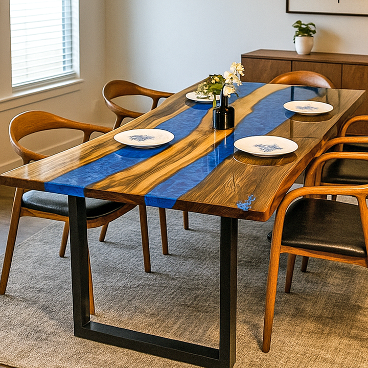 Dining table with blue resin top and wooden chairs in a room.