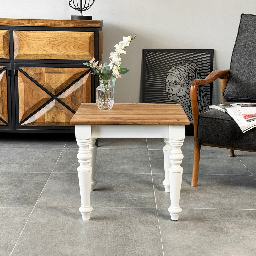 Farmhouse walnut side table with white turned legs in front of a wooden sideboard