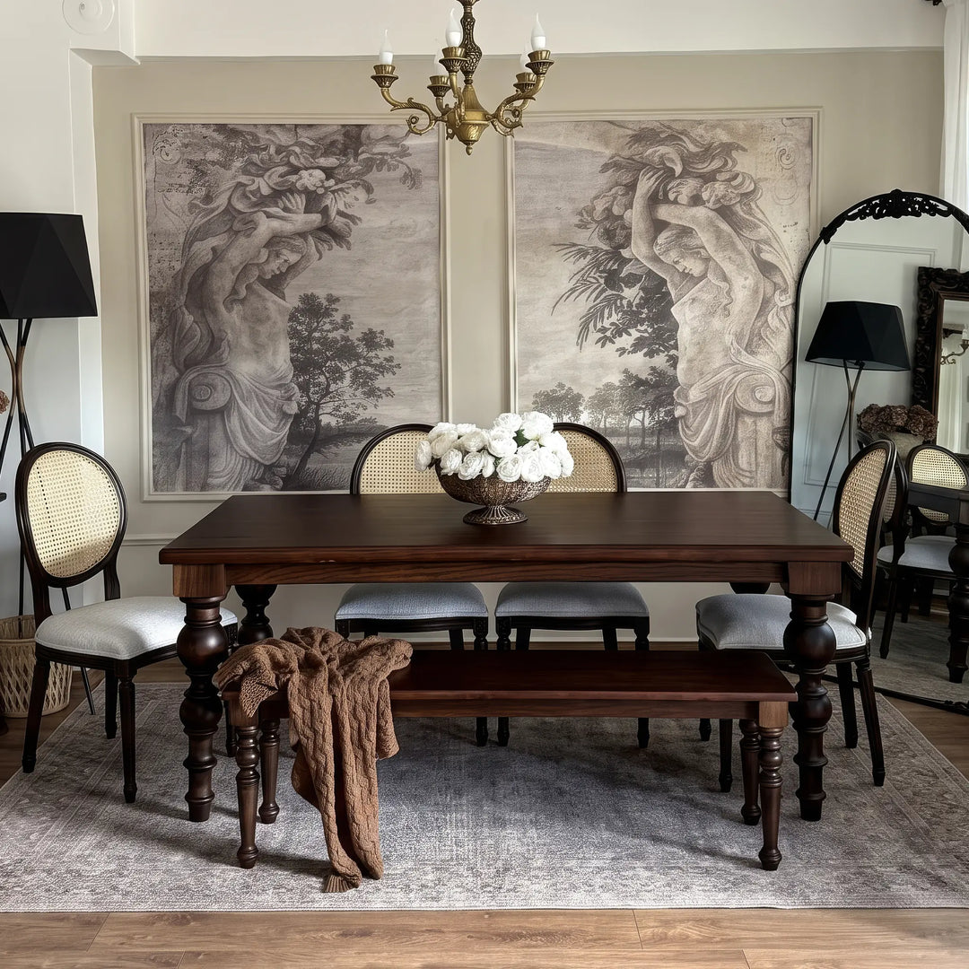 French country oak dining table with baluster legs, styled with cane back chairs and a matching bench in a formal dining room.