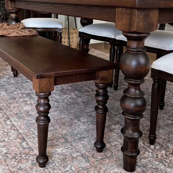 Corner view showing the oak tabletop edge, apron, and the block where the baluster leg meets the frame.