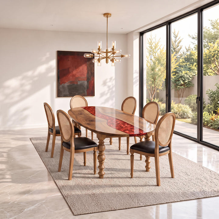 Garnet oval epoxy river dining table in solid walnut, set with six cane back chairs in a bright dining room