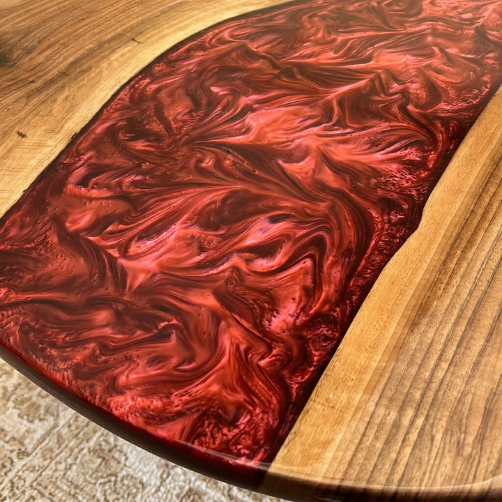 Detail of the red epoxy resin pour where the river widens across the walnut top