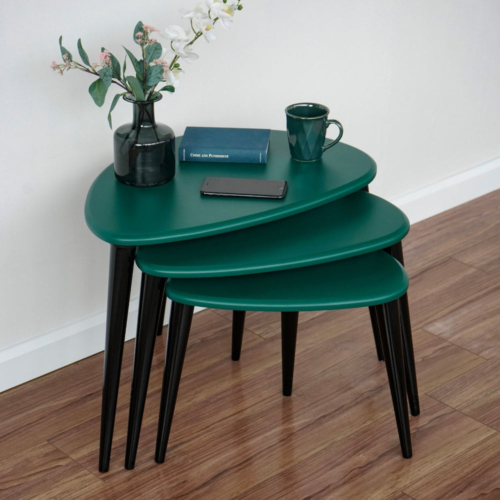 Green high gloss pebble nest of tables with black legs, close angled view with a vase on the top table