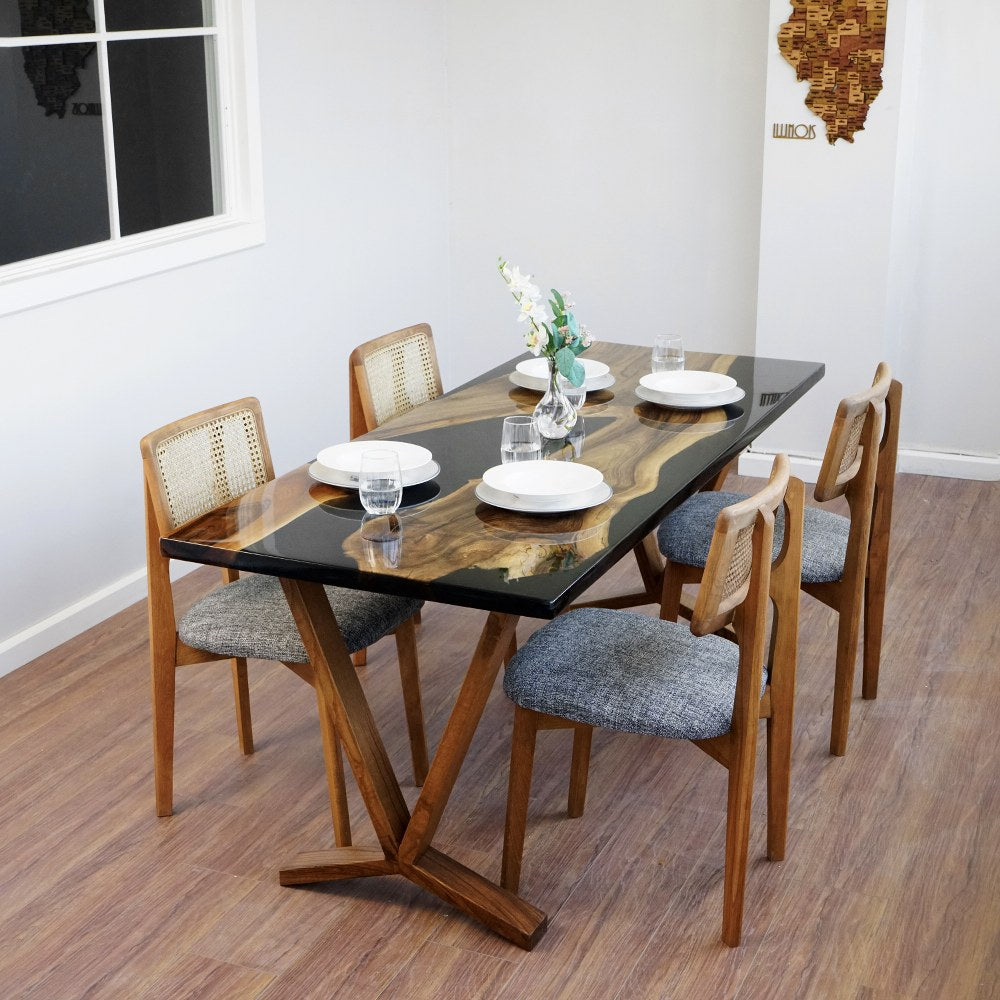 Raven black epoxy live edge table seen from above at the end, set for four with white plates