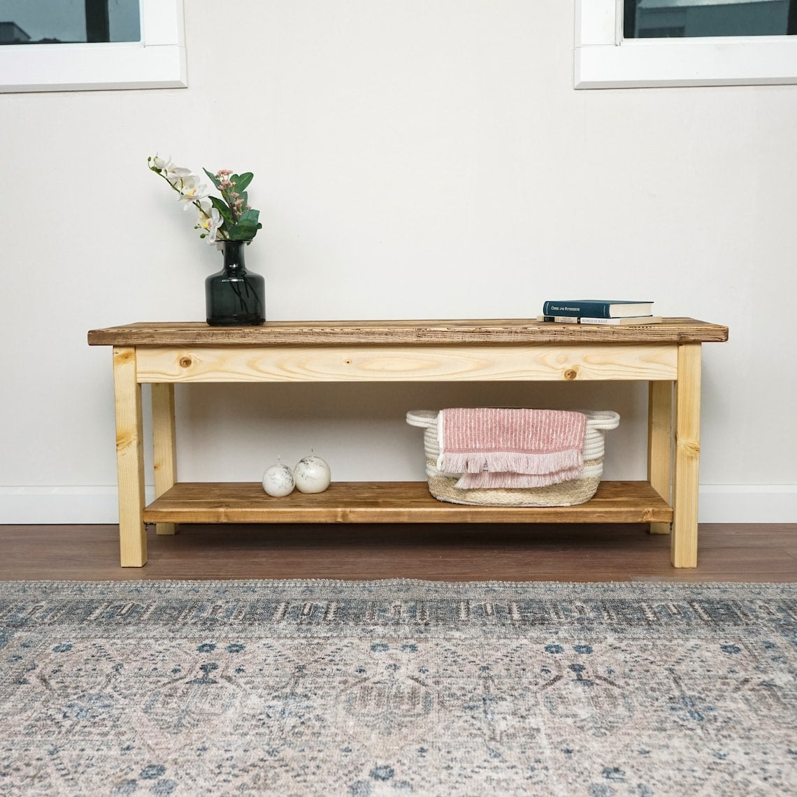 Wide front view of the spruce entryway bench with a lower shoe shelf, set on a patterned rug