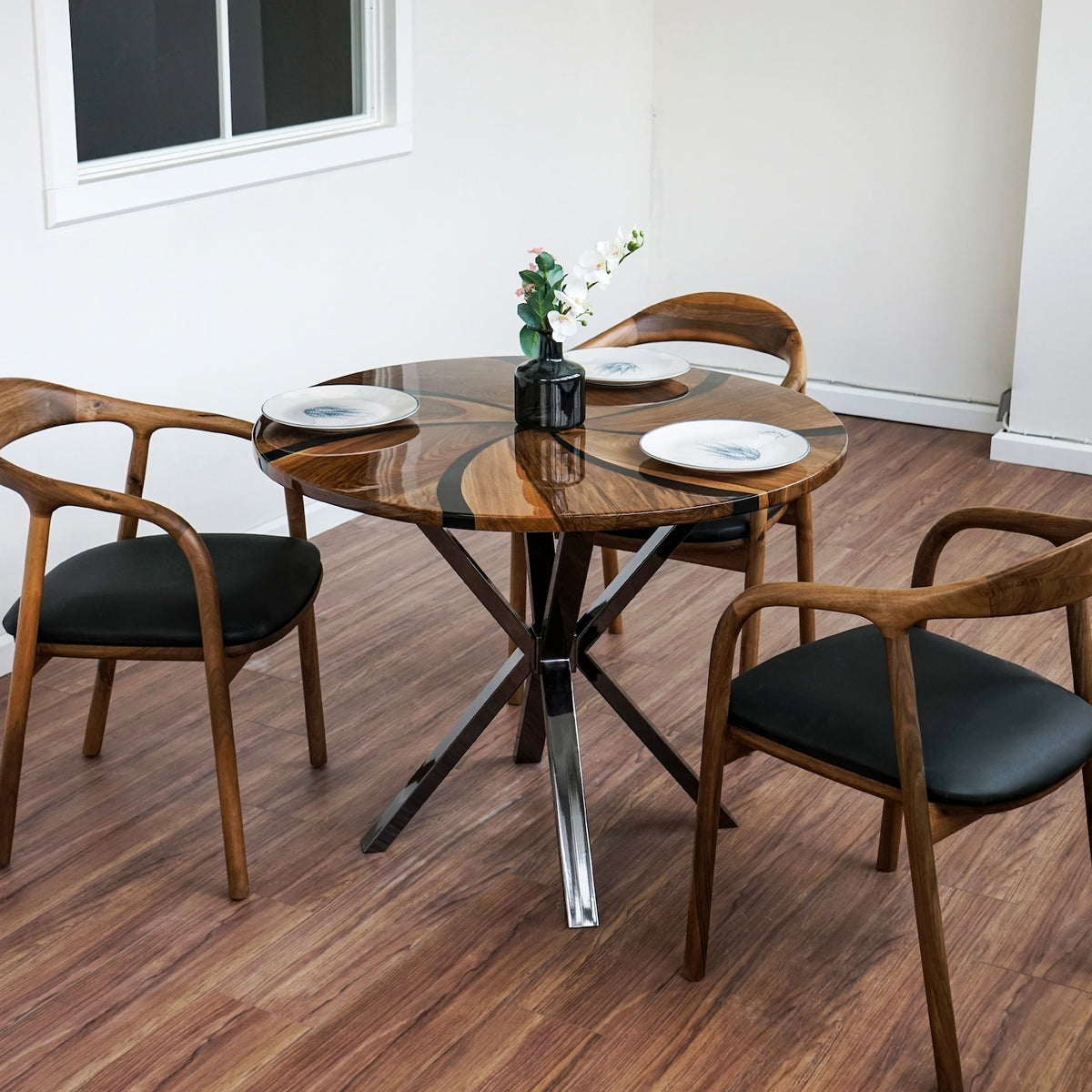 Round walnut epoxy dining table on platinum-colored crossed metal legs with two armchairs