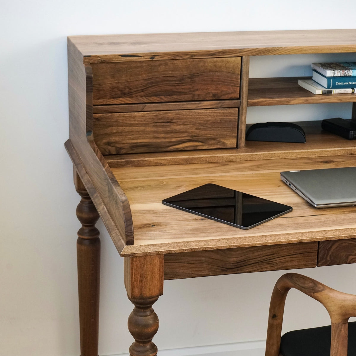 Left side of the walnut desk hutch drawers with a tablet and turned front leg