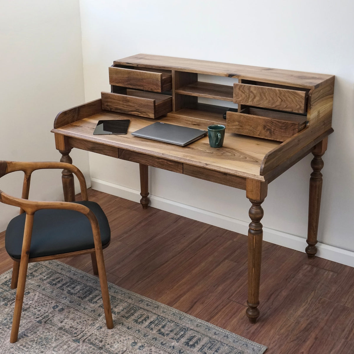 Walnut desk with the hutch drawers slightly open, seen from the right with a chair at the left