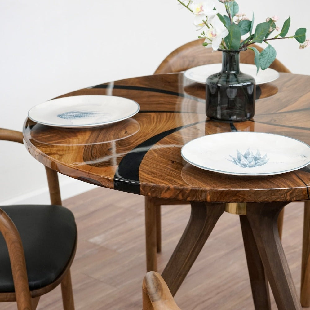 Top angle on the glossy walnut table with black epoxy swirl, plates and a vase of flowers