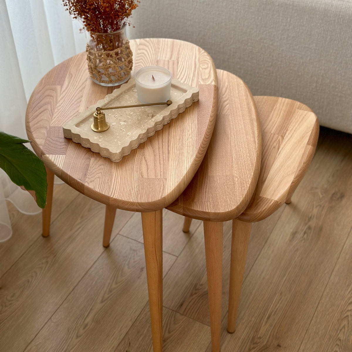 High angle of three chestnut nesting tables with joined wood strip tops