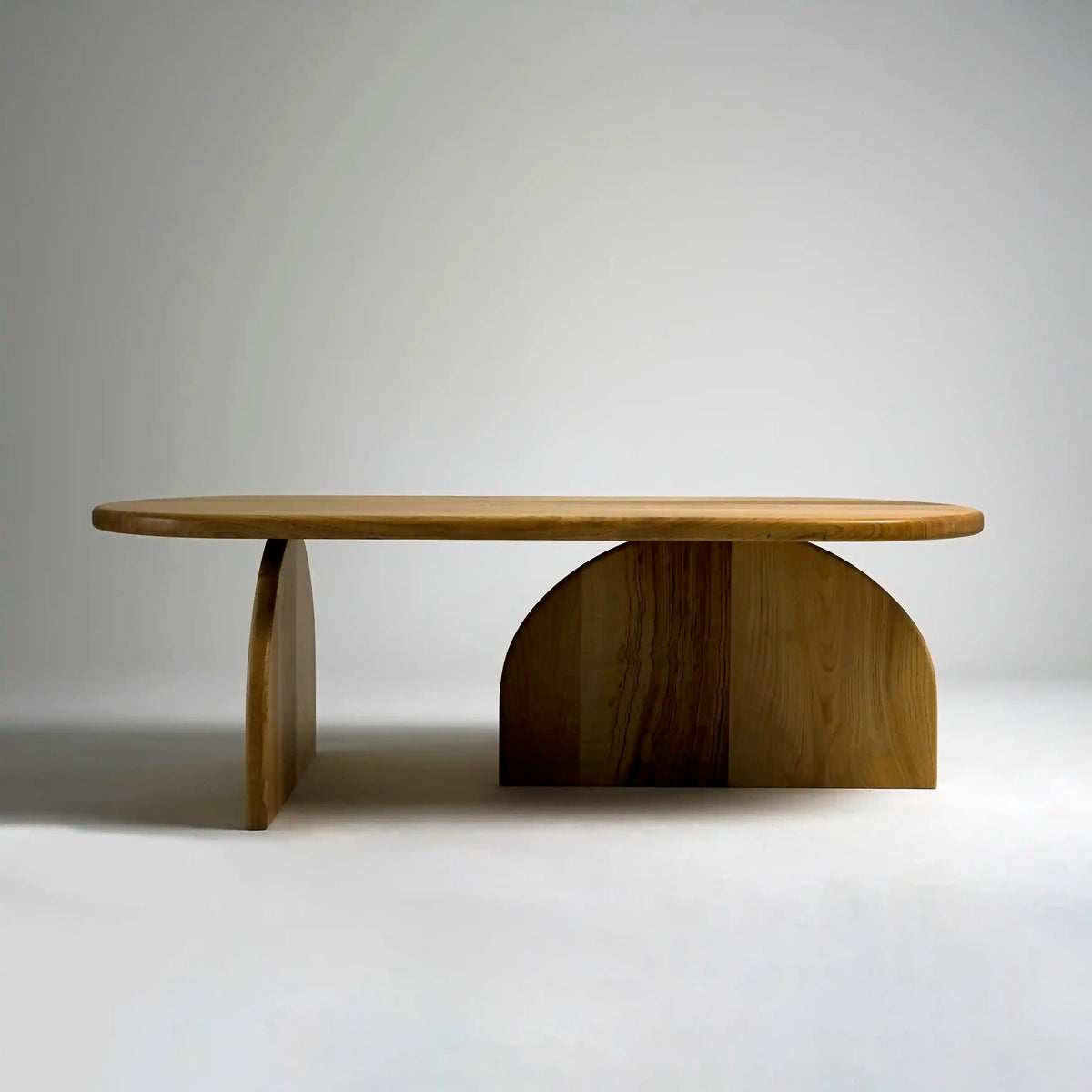 Front view of the chestnut coffee table with two half-round supports on a light floor