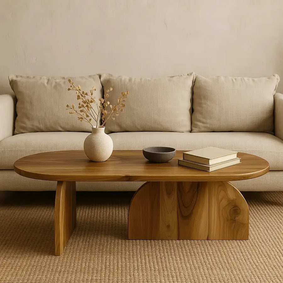 Solid walnut Japandi oval coffee table with the vertical foot base, in front of a beige sofa
