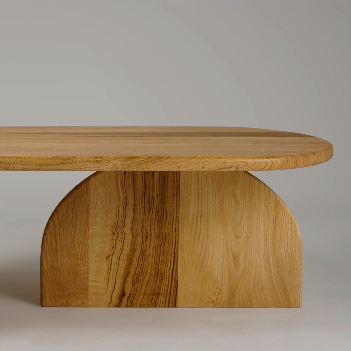 Side close-up of a half-round support under the chestnut coffee table top