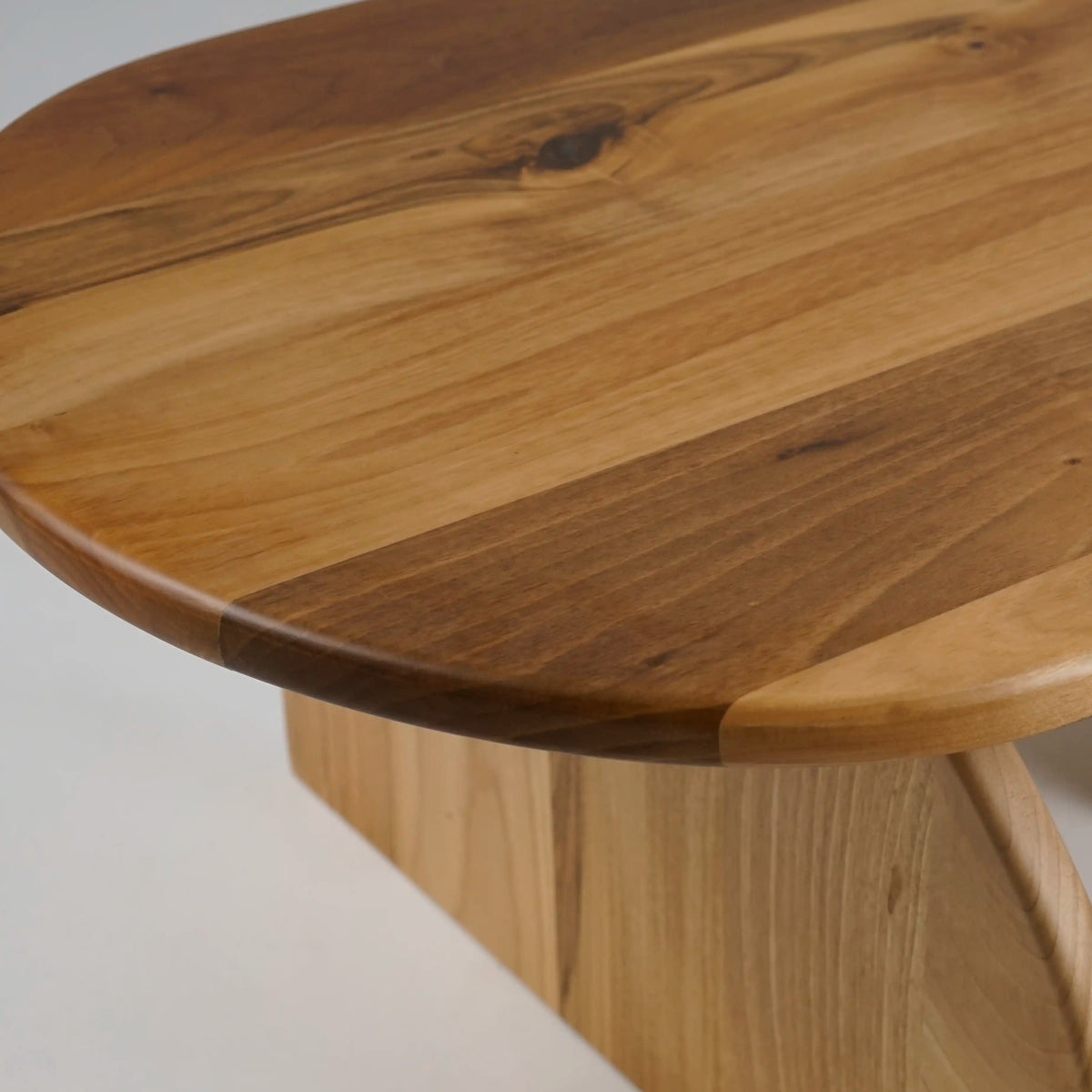 Close-up of the walnut grain and rounded edge on the oval coffee table top