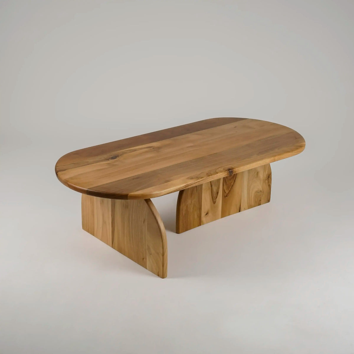 Walnut oval coffee table with half-round feet seen from the opposite high angle