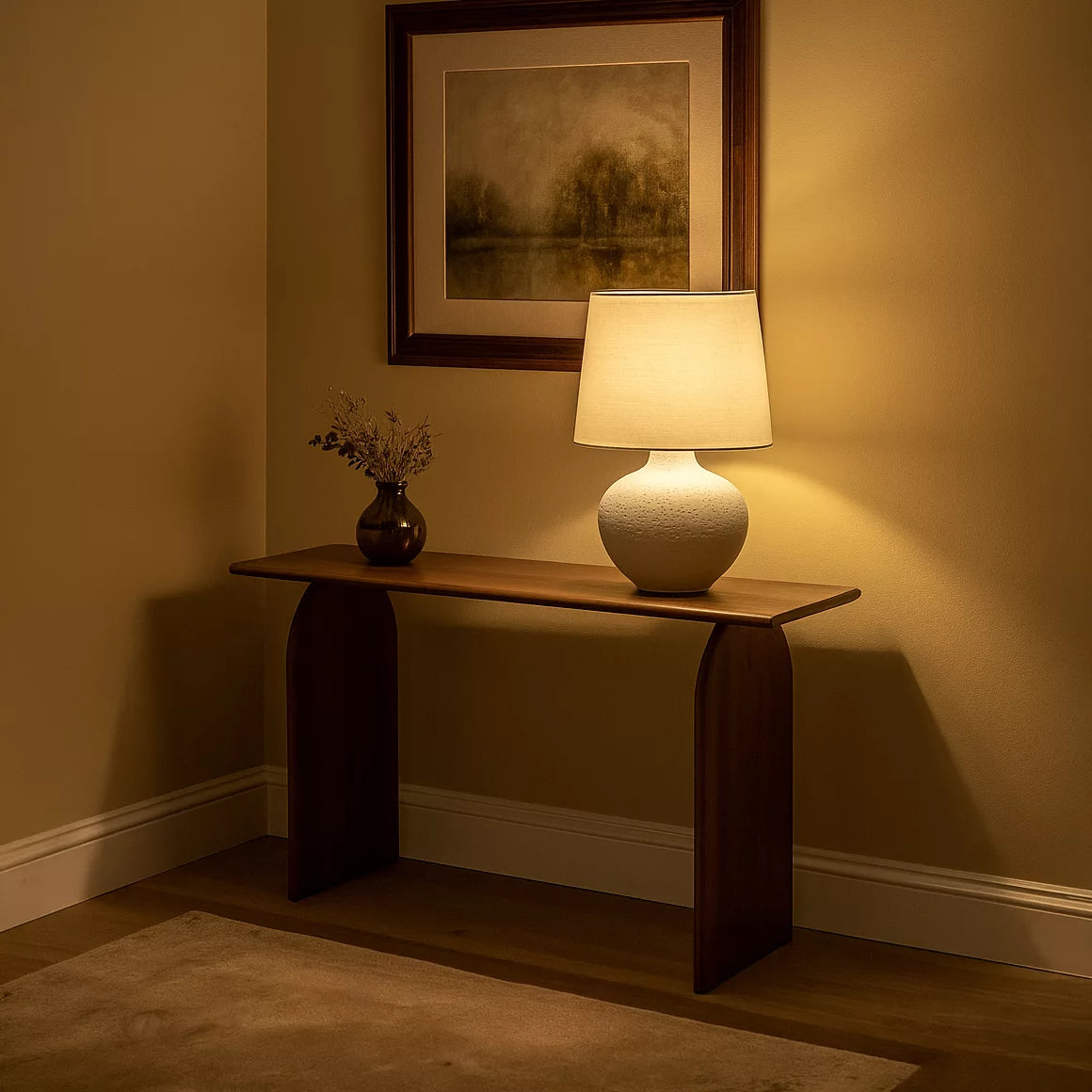 Walnut Japandi console table with arched legs in a warm-lit hallway, a ceramic table lamp on top