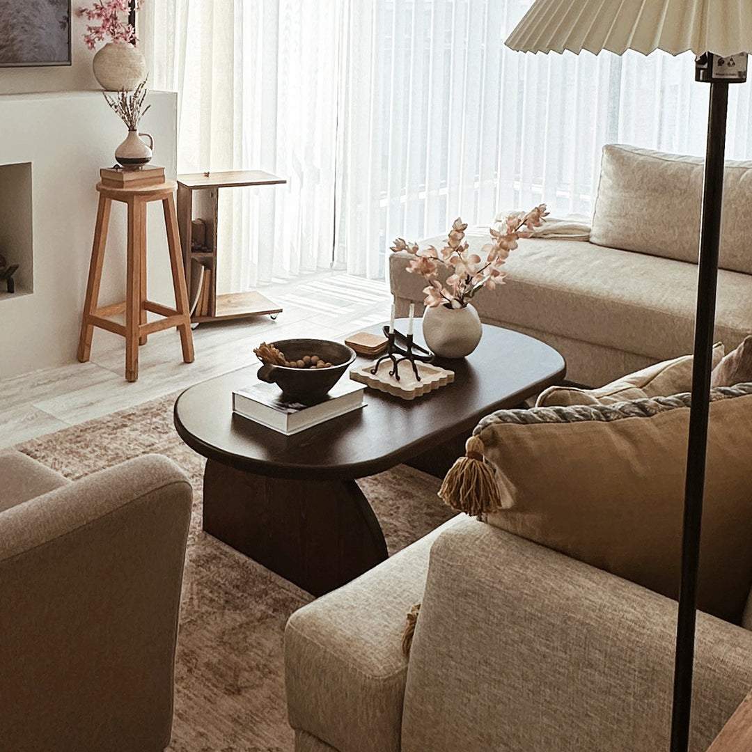 Living room with beige sofa, wooden coffee table, and decorative items.